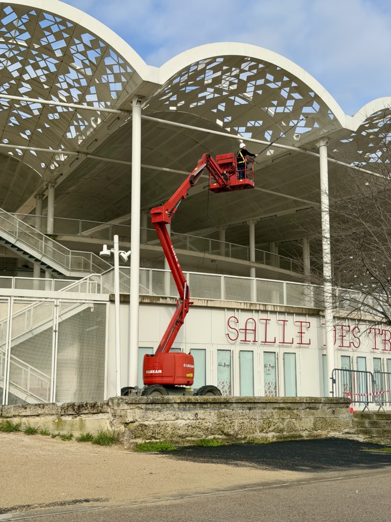 Technicien R Sud Drone en nacelle nettoyant la façade avant des Arènes de Lunel